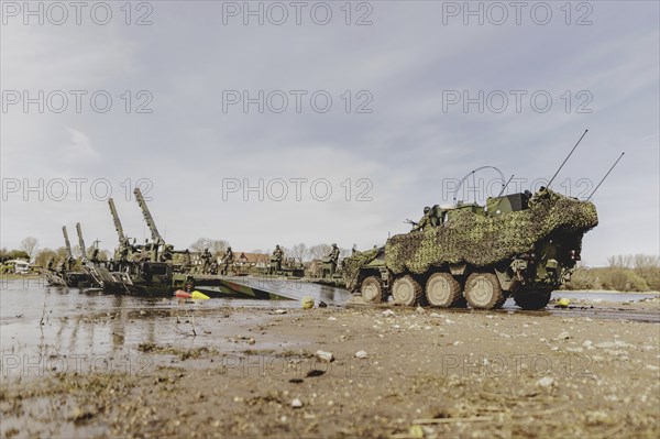 A Pandur II tank navigates the Bundeswehr's Amphibie M3 floating high-speed bridge in the Elbe as part of the military exercise 'Wettiner Schwert' with German and Czech soldiers near Tangermünde, 26 March 2024. 'Wettiner Schwert' is part of the NATO Quadriga exercise