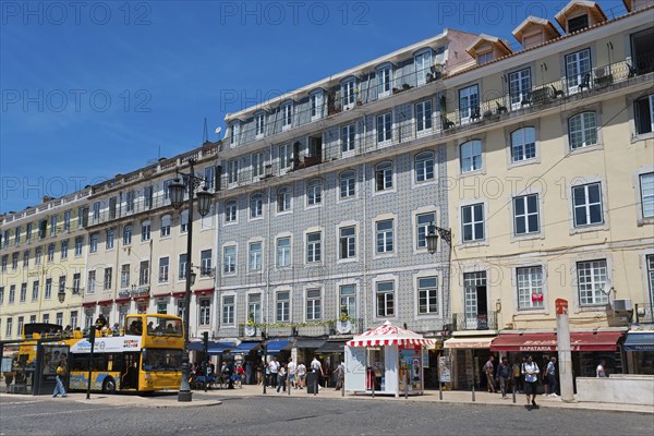 Lively street with many shops and tall buildings, people and a bus under a sunny sky, house with wall tiles, azulejos, Praça da Figueira, Baixa, Lisbon, Lisboa, Portugal, Europe