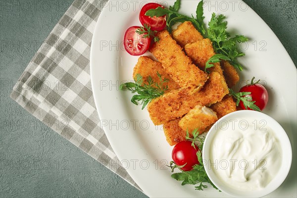 Fried fish nuggets, with white sauce, arugula and cherry, no people