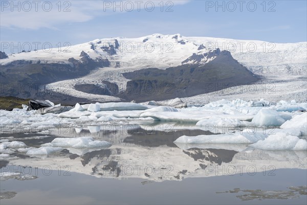 Sveinstindur peak reflected in glacier lagoon, Fjallsárlón ice lagoon, ice floes in front of Fjallsjökull glacier, Vatnajökull, Hornafjörður, Iceland, Europe