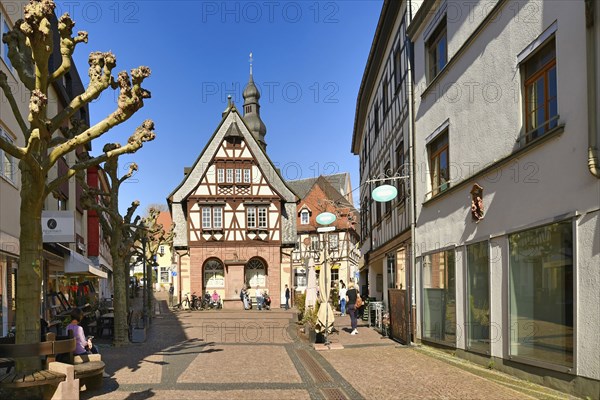 Hofheim, Germany, March 2021: Street with traditional half timbered buildings in old historic city center of Hofheim full of people on sunny day, Europe