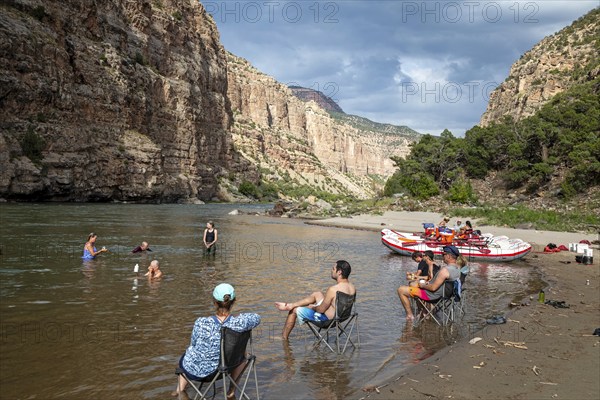 Dinosaur, Colorado, River rafters on the Green River in Dinosaur National Monument relax in the river at their evening campsite