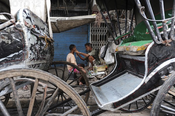 20.02.2011, Kolkata, West Bengal, India, Asia, A man gets a shave between rickshaws on a roadside in Kolkata, the only city in India where hand-pulled rickshaws still exist, Asia