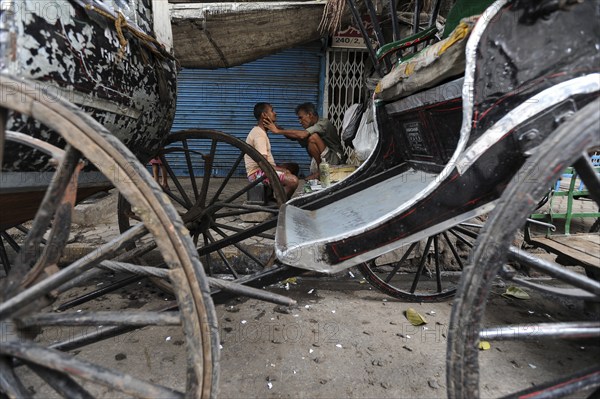 20.02.2011, Kolkata, West Bengal, India, Asia, A man gets a shave between rickshaws on a roadside in Kolkata, the only city in India where hand-pulled rickshaws still exist, Asia