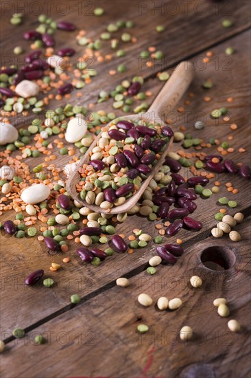 Mixed seed legumes in a spoon on old wooden table