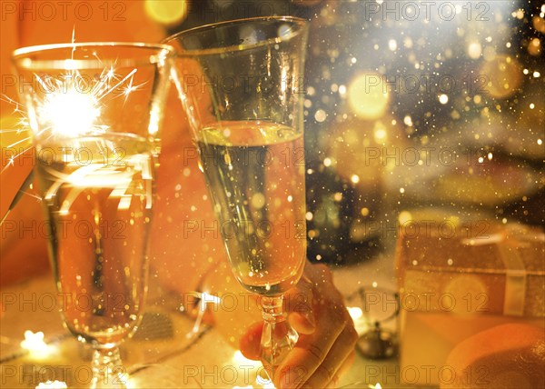 Sparklers in a glass of champagne, transparent glass with wine and splashes. New Year, festive mood, celebration. Christmas