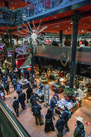 12-23-2023 BERLIN In booking store before Christmas People doing gidts (maybe for himself or gerself), they walking and reading (choosing) inside perfect Dussmann das KulturKaufhaus in Berlin. Store on Friedrichstrasse in downtown next to Unter den Linden