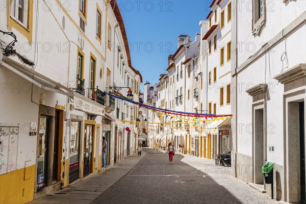 Evora, Portugal, June 30, 2022: Street in the old town with typical whitewashed houses with balconies. Alentejo, Portugal, Europe