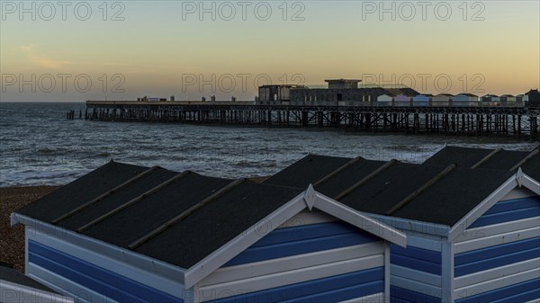 Hastings, East Sussex, England, UK, May 11, 2022: Evening mood on the beach, with some beach huts and the pier