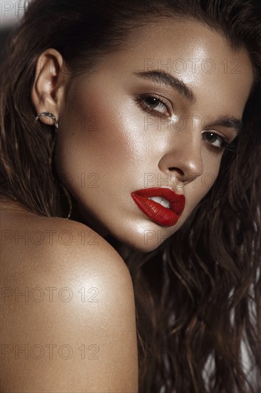 Beautiful sexy girl with bright makeup, red lips, wet hair. Beauty face. Photo taken in studio