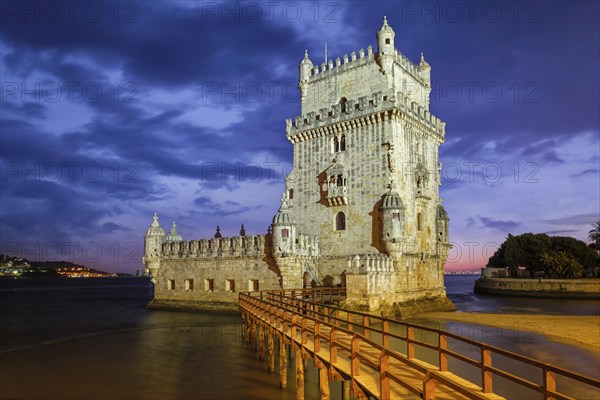 Belem Tower or Tower of St Vincent, famous tourist landmark of Lisboa and tourism attraction, on the bank of the Tagus River (Tejo) after sunset in dusk twilight with dramatic sky. Lisbon, Portugal, Europe