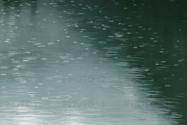 Raindrops on emerald green reservoir, Stillup reservoir, Stilluptal, Mayrhofen, High Mountain nature park Park Zillertal Alps, light reflections, Tyrol, Austria, Europe