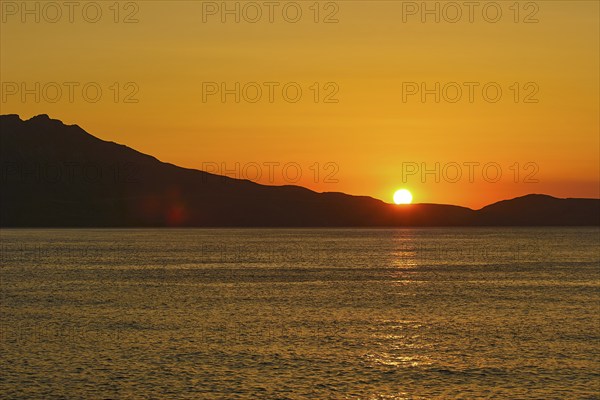 Sunset, sun ball over Gramvoussa peninsula, sun reflection on the sea, orange sky, Rodopou peninsula, Pirate Bay, Balos, Tigani, West Crete, island of Crete, Greece, Europe