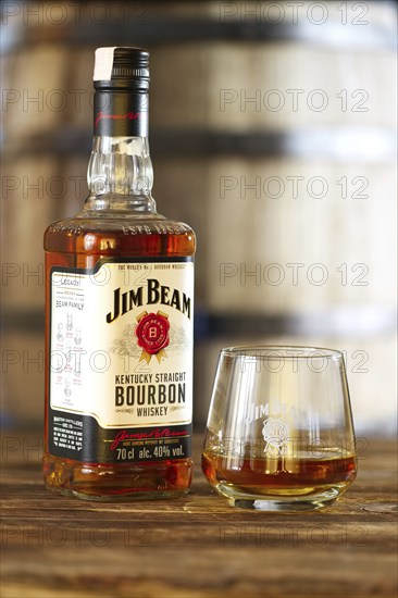 March 28, 2019, Minsk, Belarus, Bottle of kentucky straight bourbon whiskey with glass on wooden table with barrel on background, Europe