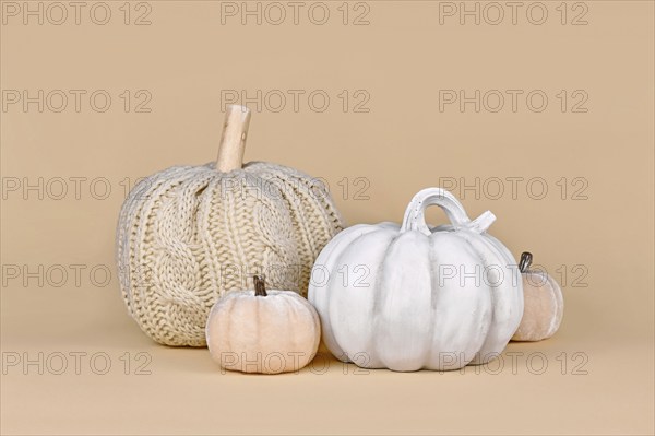 Autumn decoration with boho style knitted beige pumpkin and gray stone pumpkin