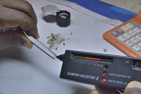 Diamond dealer inspecting a diamond for its authenticity, Koidu, Koidu-Sefadu, Kono District, Eastern Province, Sierra Leone, Africa