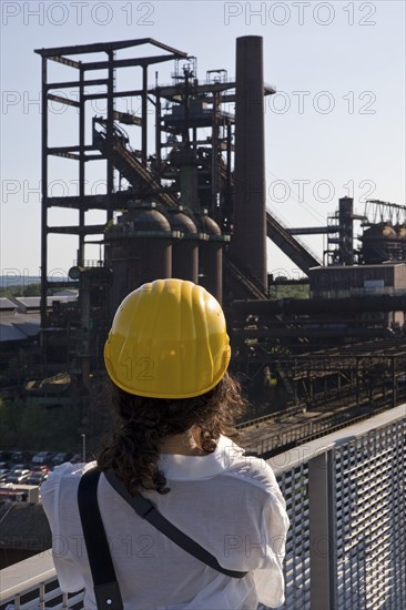 Woman on the skywalk photographing the blast furnace of the former industrial plant Phoenix West, Dortmund, Ruhr area, North Rhine-Westphalia, Germany, Europe