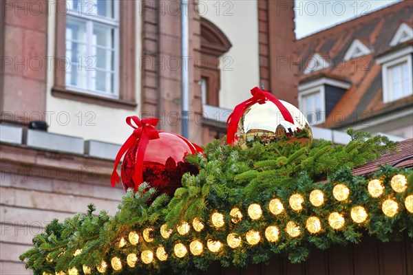 Heidelberg, Germany, November 2019: Huge red and white tree baubles with ribbon on rooftop as part of seasonal decoration on traditional Christmas market in Heidelberg city center, Europe