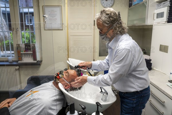 Hairdressing salon in Essen-Rüttenscheid, first customer after 6 weeks, shop closed due to Corona, hairdresser and customer with mouth-nose protection, breathing mask, Plexiglas protective walls, spit protection, when washing hair, distance regulation, Essen, North Rhine-Westphalia, Germany, Europe