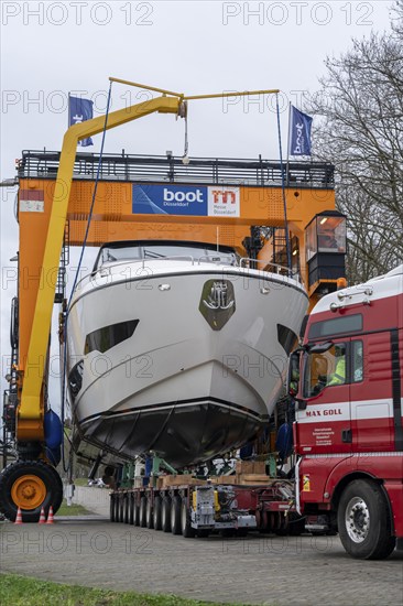 Craning the €6.3 million Sunseeker 88Y motor yacht, weighing 82 tonnes, in preparation for the world's largest water sports trade fair, Boot in Düsseldorf, luxury yachts are driven across the Rhine to the trade fair and brought ashore with the help of the Big Willi ship crane and transported to the exhibition halls on a low-loader, North Rhine-Westphalia, Germany, Europe