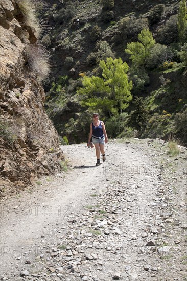 Woman walking in the the River Rio Poqueira gorge valley, High Alpujarras, Sierra Nevada, Granada Province, Spain, Europe