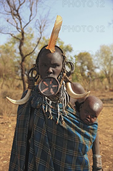 South Ethiopia, in Maco National Park, Mursi tribe, Mursi woman with baby, painted skin and headdress, plate lip woman, woman with plate in lower lip, lip jewellery, Ethiopia, Africa