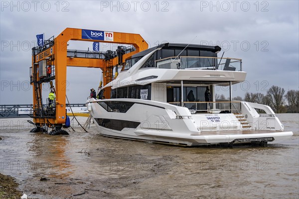 Craning the €6.3 million Sunseeker 88Y motor yacht, weighing 82 tonnes, in preparation for the world's largest water sports trade fair, Boot in Düsseldorf, luxury yachts are driven across the Rhine to the trade fair and brought ashore with the help of the Big Willi ship crane and transported to the exhibition halls on a low-loader, North Rhine-Westphalia, Germany, Europe