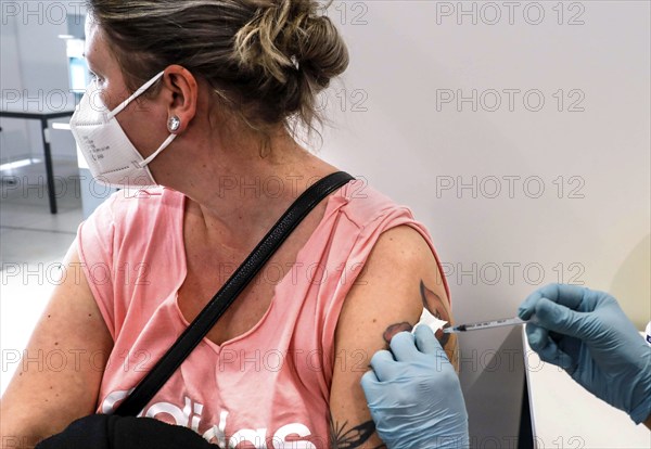 A woman receives a booster vaccination from Moderna against Covid 19 at the Schönefeld vaccination centre, 03.12.2021