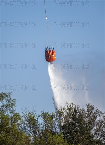 Forest fire in the German-Dutch border region near Niederkrüchten-Elmpt, in a nature reserve, use of fire-fighting helicopters, Boeing CH-47 Chinook helicopter, of the Dutch Air Force with extinguishing water tank, Bambi Bucket max