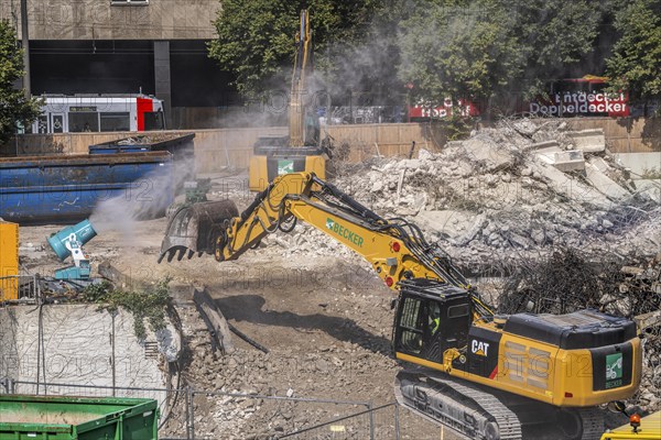 Water cannon, snow cannon, sprays water onto the construction site on Haroldstraße, against dust formation, demolition of a former office building, after complete gutting only the concrete parts remain, large excavator steel wire, Düsseldorf, North Rhine-Westphalia, Germany, Europe