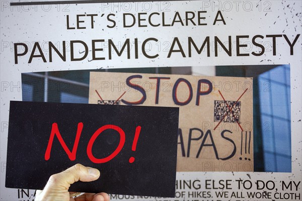 Symbolic image of Pandemic Amnesty: a section of a symbolic newspaper with a sign reading NO held in front of it. In the USA and many other countries, a debate has begun on coming to terms with the corona measures