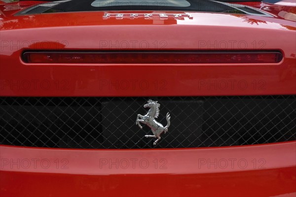 Close-up detail of red rear end of sports car Supercar Ferrari Spyder with logo trademark of luxury car manufacturer Jumping horse Cavallino Rampante, international