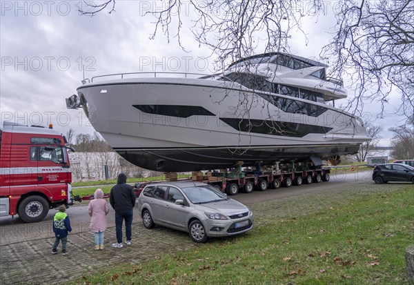 Craning the €6.3 million Sunseeker 88Y motor yacht, weighing 82 tonnes, in preparation for the world's largest water sports trade fair, Boot in Düsseldorf, luxury yachts are driven across the Rhine to the trade fair and brought ashore with the help of the Big Willi ship crane and transported to the exhibition halls on a low-loader, North Rhine-Westphalia, Germany, Europe