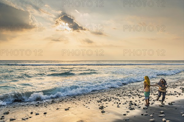 Muslim woman in the evening sun at Mangsit beach in Sengiggi, Islam, religion, headscarf, travel, tourism, sea, beach, water, respect, dramatic, drama, emotion, play, joy, surf, surf, ocean, island, coast, tropical, tropics, Asian, natural landscape, untouched, tourism, holiday, lonely, deserted, calm, authentic, authenticity, original, atmosphere, holiday mood, long-distance travel, tradition, traditional, poverty, culture, tradition, holiday idyll, Lombok, Indonesia, Asia