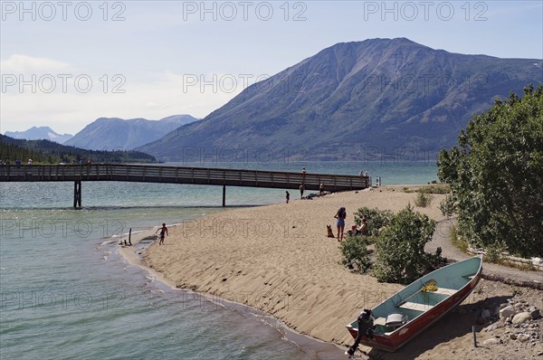 Boat, footbridge on a sandy beach, Bennett Lake, Yukon Territory, Canada, North America