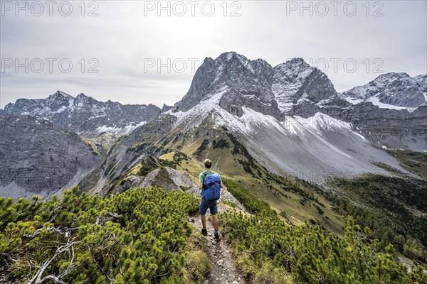 Mountaineers on a hiking trail on the ridge of Hahnkampl, mountain panorama with rocky steep peaks, view of summit Lamsenspitze, in autumn, Karwendel Mountains, Alpenpark Karwendel, Tyrol, Austria, Europe