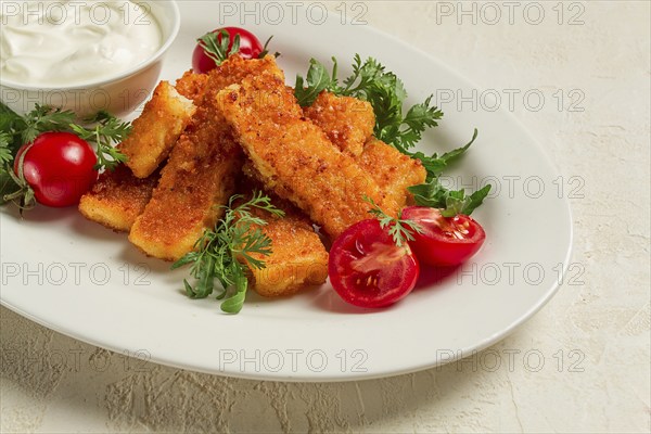 Fried fish nuggets, with white sauce, arugula and cherry, no people