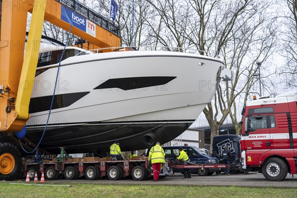 Craning the €6.3 million Sunseeker 88Y motor yacht, weighing 82 tonnes, in preparation for the world's largest water sports trade fair, Boot in Düsseldorf, luxury yachts are driven across the Rhine to the trade fair and brought ashore with the help of the Big Willi ship crane and transported to the exhibition halls on a low-loader, North Rhine-Westphalia, Germany, Europe