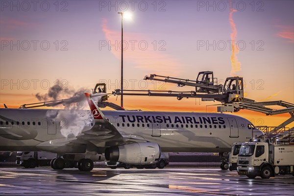 Frost at the airport, a Turkish Airlines aircraft is de-iced in front of sunrise. Airbus A321-231, Fraport, Frankfurt am Main, Hesse, Germany, Europe