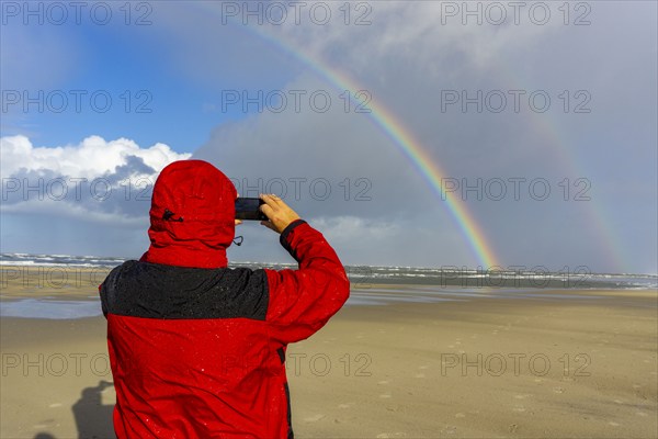 North Sea, Spiekeroog Island, autumn, rainy weather, with sun, rainbow, East Frisian Islands, beach walker take a photoLower Saxony, Germany, Europe