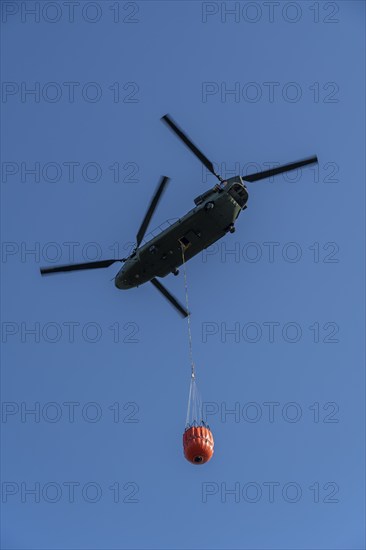 Forest fire in the German-Dutch border region near Niederkrüchten-Elmpt, in a nature reserve, use of fire-fighting helicopters, Boeing CH-47 Chinook helicopter, of the Dutch Air Force with extinguishing water tank, Bambi Bucket max