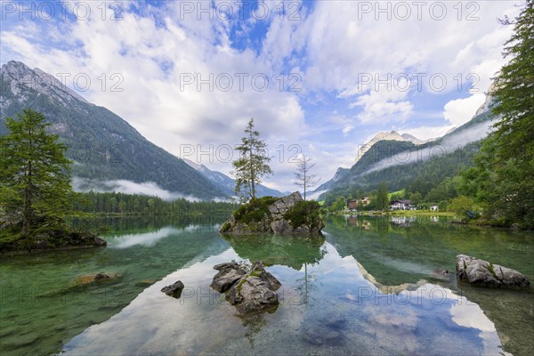 Hintersee with rocks and trees in the foreground, surrounded by mountains, cloudy sky, Ramsau, Berchtesgaden National Park, Berchtesgadener Land, Upper Bavaria, Bavaria, Germany, Europe