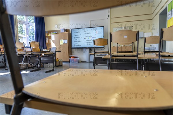 Classroom of a fourth grade, after school, the building is older but in good condition, modern teaching materials, interactive, digital whiteboard