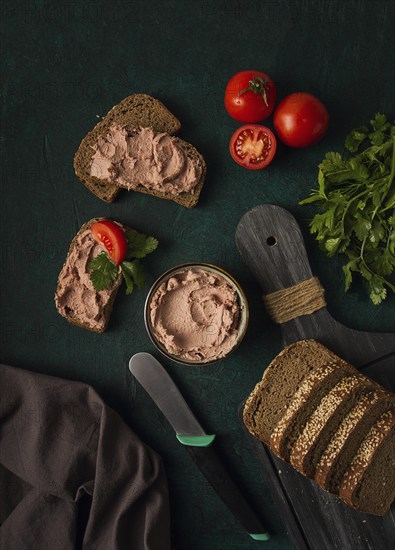 Liver meat pate spread on rye bread, breakfast, close-up, dark background. no people, selective focus