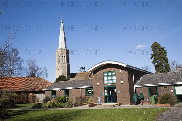 The octagonal tower of All Saints church, Wickham Market, Suffolk, England with public library and community rooms in foreground