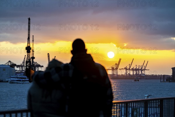 Port of Hamburg, couple looking at the Blohm + Voss shipyard, evening, cranes of the container terminals, sunset, Hamburg Germany