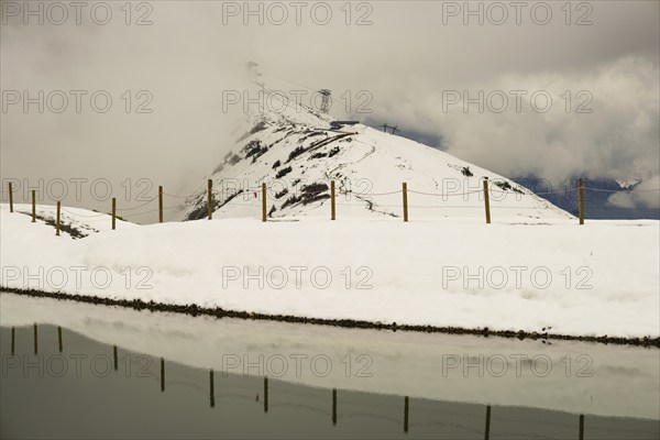 After snowfall in May: Riezler Alpsee, an artificial lake, snow pond, feeds the snow cannons that completely cover the slopes of the Fellhorn and Kanzelwand cable cars with snow, Allgäu Alps, Vorarlberg, Austria, Europe