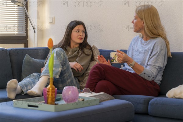 Mother and daughter, teenage, 13 years old, in a confidential conversation, at home