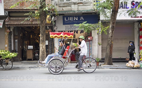 Vietnamese rickshaw driver in the Old Quarter of Hanoi, Vietnam, Asia