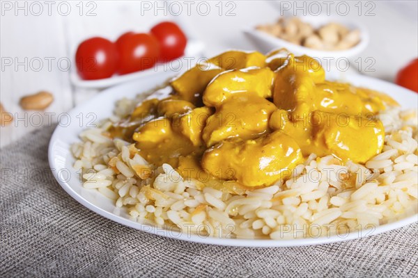 Rice with chicken curry sauce with cashew on white wooden background. selective focus, close up